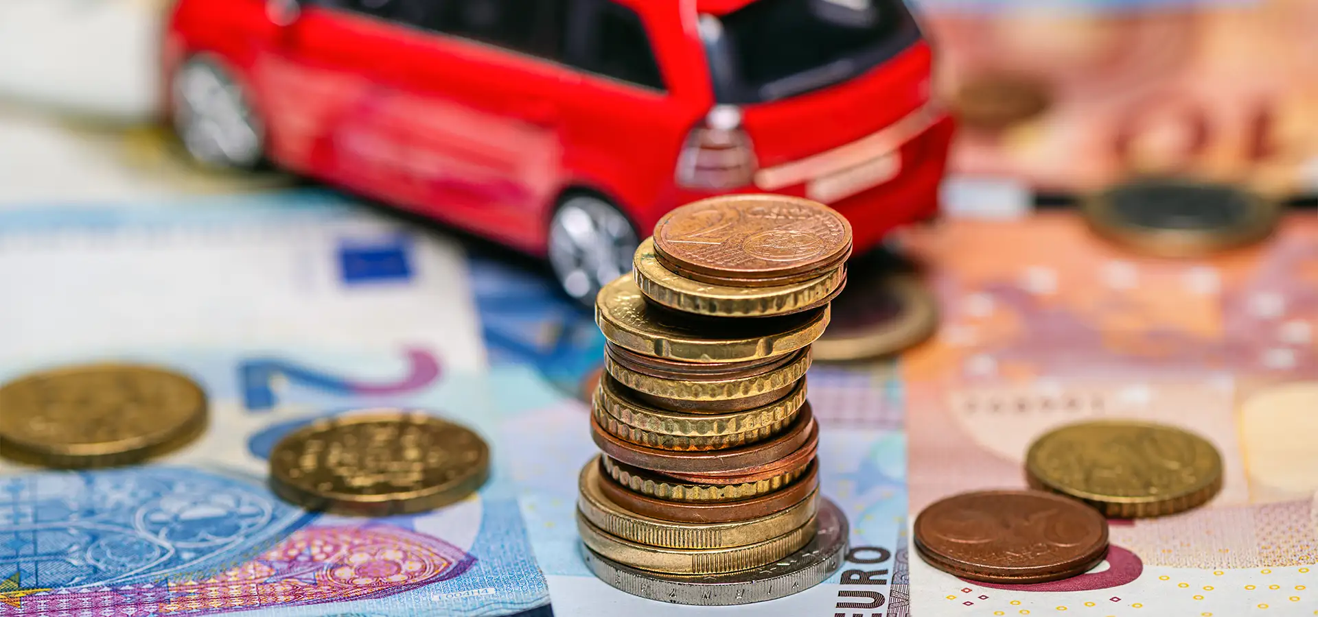 Imagen de una maqueta de coche con el dinero de los impuestos del renting